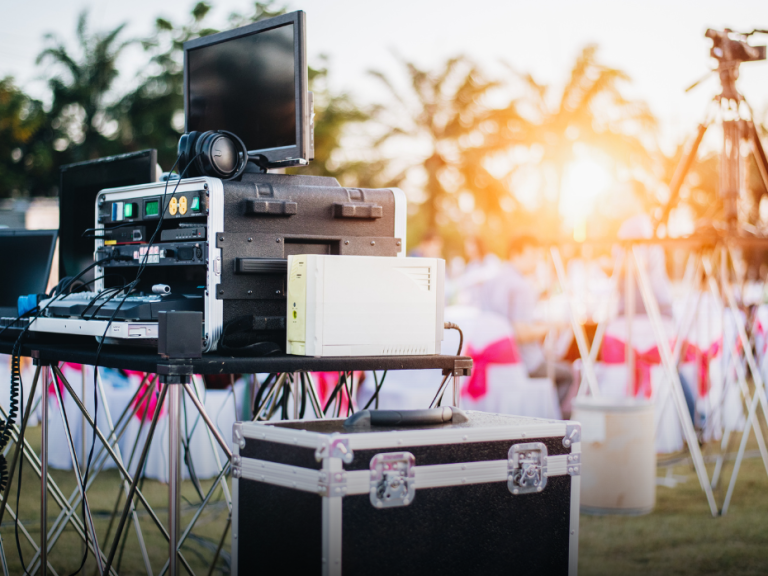 Audio- und Video-Equipment auf einem Event, umgeben von Dekoration und Pflanzen.